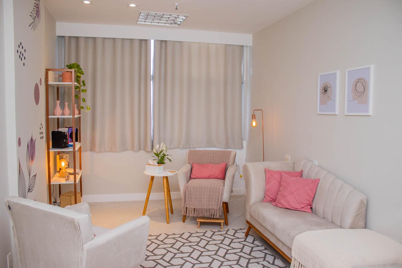 Consultório acolhedor com poltronas, planta e luz natural